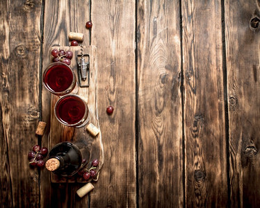 红葡萄酒在木板上与塞子和螺丝起子。在一张木桌上。红葡萄酒在木板上与塞子和螺丝起子。