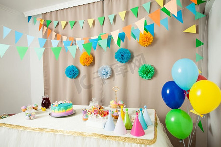 生日快乐庆祝蛋糕摄影照片_房间内有装饰过的桌子，为生日快乐派对准备的，没有人。生日快乐装饰品