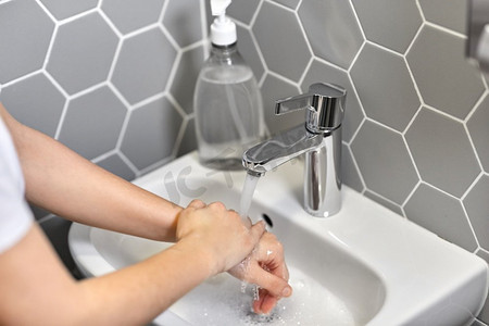 卫生间洁具摄影照片_卫生、保健及安全概念—妇女用肥皂洗手特写。特写妇女洗手用液体肥皂