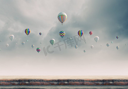 空中飞球摄影照片_会飞的浮空器。五颜六色的气球在灰色的天空中高高飘扬