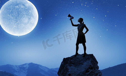 拿着扩音器的女人。一名年轻女子在满月之际用扩音器讲话