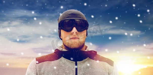 滑雪护目镜摄影照片_人与冬季运动概念-戴着滑雪护目镜的年轻人在户外。冬季户外戴着滑雪护目镜的运动员