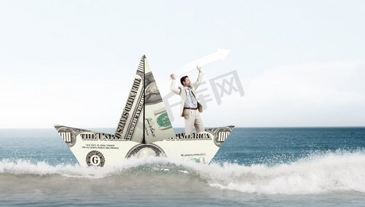 商人钞票摄影照片_商人在美元钞票制成的船。成功的商人航行在美元船在金融海