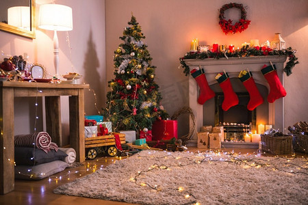 在家里客厅壁炉旁的圣诞树上放着礼物。壁炉旁摆放着礼物的圣诞树