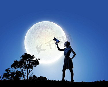 拿着扩音器的女人。一名年轻女子在满月之际用扩音器讲话