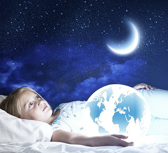 励志晚安摄影照片_晚安。女孩在床上，手里拿着地球