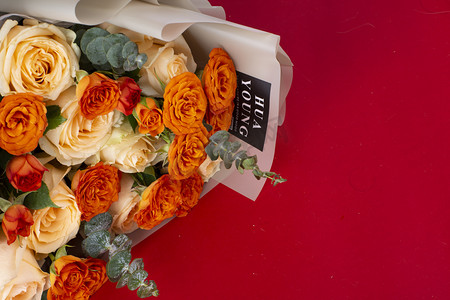 橘色花朵摄影照片_红底鲜花美丽鲜艳花束礼物送礼情人节爱情鲜花玫瑰捧花