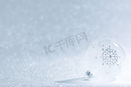 圣诞节装饰品透明球与雪花设计在银闪光背景。圣诞装饰球