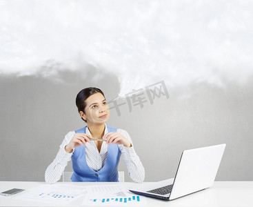 工作中沉思的女人。坐在桌边的美女拿着笔记本电脑，若有所思地看着言语云