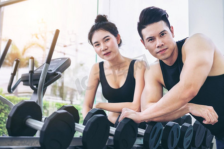 健康的男人和女人做重量训练在健身房健身中心。健身概念健康的男人和女人做重量训练在健身房