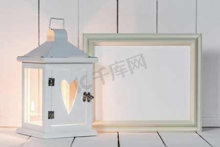 情人节饰摄影照片_灯笼和相框。白色木质背景上饰有心形和相框的蜡烛灯