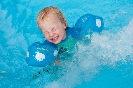 空军臂章摄影照片_戴着臂章游泳并被溅起水花的幼儿