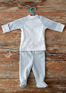 婴儿期和服装概念-婴儿服装套装衬衫和连衣裤与挂在木桌上。木桌上的婴儿衣架套装