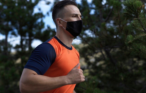 一名运动男子带着防护面罩在乡村道路上奔跑