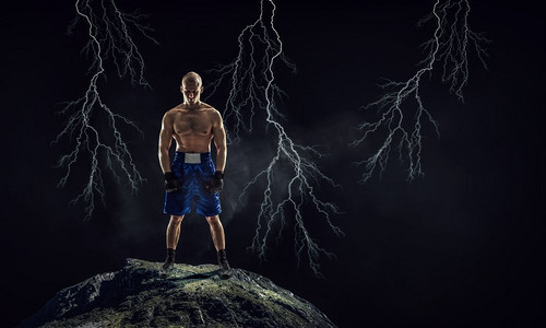 拳击手户外训练强大的拳击手在黑暗的背景展示力量和耐力