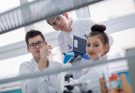 一群年轻医学生在化学实验室一起研究，大学生在室内团队合作美女人物特写