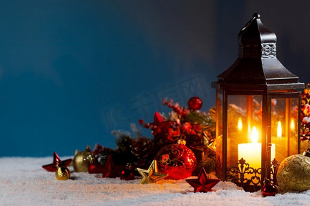 有燃烧的蜡烛的圣诞节背景在灯笼和小物件装饰在雪。圣诞灯笼和装饰品