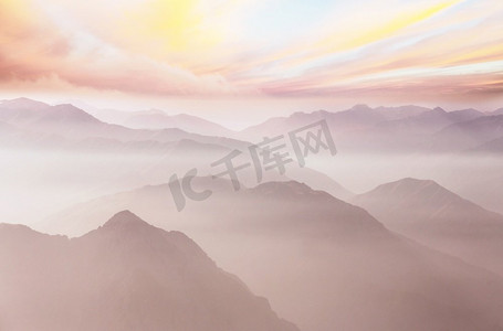 魔法山摄影照片_日出时群山的轮廓。美丽的自然背景。