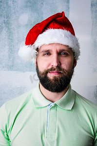 快乐的大胡子男人。圣诞节庆祝肖像--戴着圣诞帽的留着胡须的年轻人