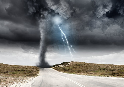 乡村道路摄影照片_自然灾害。强大的龙卷风和闪电以上的乡村道路