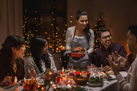 节日和庆祝概念—多民族的快乐朋友在家里吃圣诞晚餐。快乐的朋友在家里吃圣诞晚餐