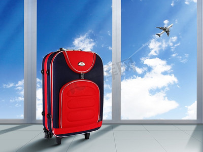 头顶蓝天上的红色行李箱和飞机