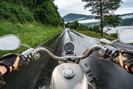 人在雨中摄影照片_骑摩托的人在雨中骑摩托车。第一人称视角。