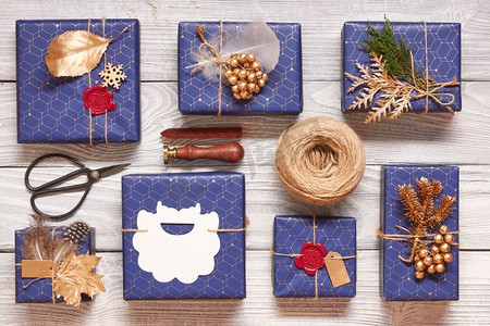 包装密封摄影照片_创意包装和装饰的圣诞礼物在白色木制背景的盒子里。从上面俯瞰。平躺着。