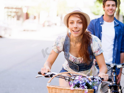 城市里骑着自行车的幸福夫妻。幸福的年轻夫妇在城市里骑着自行车