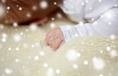 儿童、人和护理概念-婴儿躺在雪地上柔软的毛毯上的特写。婴儿躺在柔软的毛毯上的特写