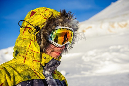 戴着滑雪护目镜的年轻人在户外，背景是法国阿尔卑斯山被白雪覆盖。Vald&rsquo；伊斯雷尔，法国