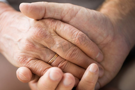 关系、婚姻和老人观念--老年夫妇牵手的特写。年长夫妇手牵手的特写