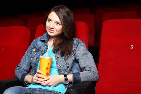 看电影摄影照片_年轻女孩坐在电影院里看电影