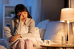 人、就寝时间和休息概念-压力很大的亚洲女性晚上在床上头痛。压力很大的亚洲女性晚上坐在床上