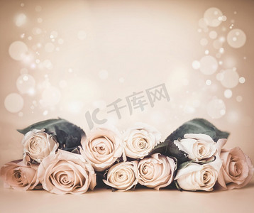 米色的花卉背景，桌上有玫瑰花和波克。节日问候或婚礼概念