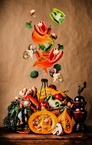 蔬菜落摄影照片_秋天的蔬菜落在厨房餐桌上的篮子里。会飞的食物。健康素食、饮食和烹饪