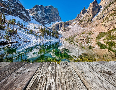 木板雪摄影照片_翡翠湖和反射与岩石和山脉在雪周围在秋天。美国科罗拉多州落基山国家公园。