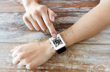科技与养生理念--女性特写&S手持智能手表二维码。女性&S在智能手表上牵着二维码