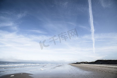 海边蓝天空摄影照片_北部海滩与波浪形成在戏剧性的蓝天下