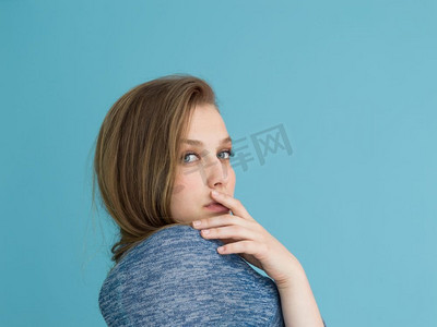 丝质摄影照片_一位美丽积极的年轻女子一边玩耍着蓝色背景下孤立的丝质长发