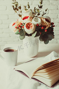 桌上放着一杯红茶、一本笔记本和一朵美丽的花。早晨计划一天的灵感。解决难题的启示