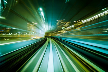 动态背景城市摄影照片_城市轨道隧道中行驶的运动模糊列车。运动模糊背景摘要。