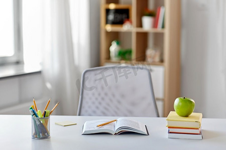 教育和学习概念书，苹果和学校用品在家里的桌子上。书，苹果和学校用品在家里的桌子上