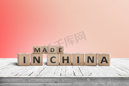 在中国制造的标志在一个木桌子与红色的墙壁在背景