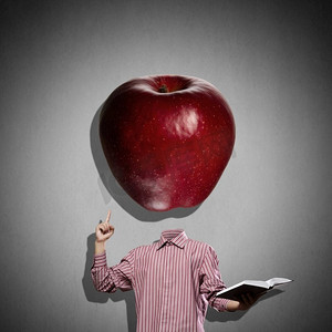 拿着苹果摄影照片_伟大的思想。手里拿着书，拿着苹果而不是脑袋的商人