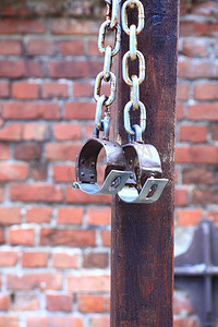砖摄影照片_老脚镣，手铐砖两个老生锈的铁环在墙背景