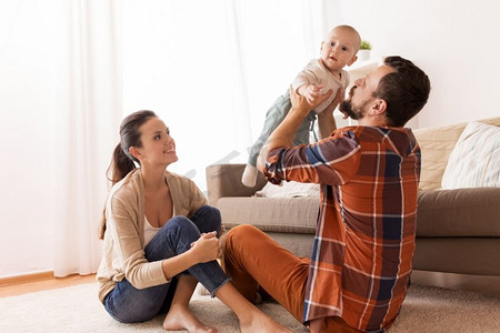 家庭、父母和人的概念-快乐的父母和孩子在家里玩耍。快乐的爸爸妈妈在家陪着宝宝玩耍