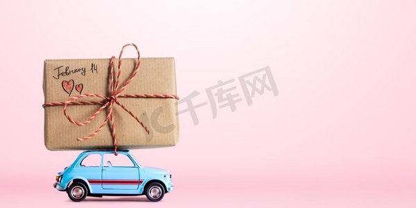 蓝色复古玩具车送货礼盒，粉色背景，2月14日情人节标题
