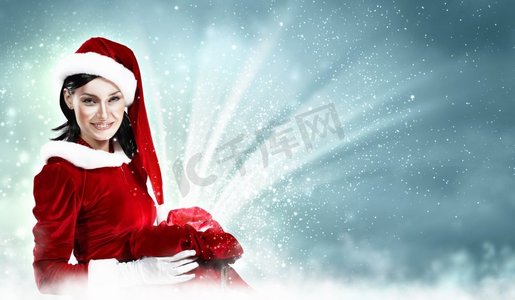 装饰画摄影照片_穿着圣诞老人服装的漂亮女孩。圣诞老人装扮的美丽女孩圣诞装饰画