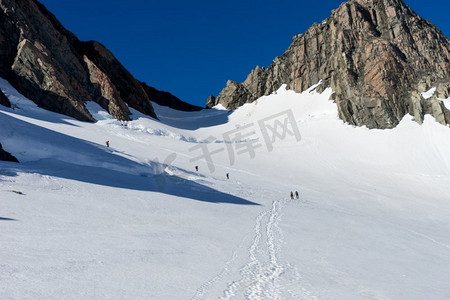 新西兰。在新西兰山区的雪地中行走的一群人